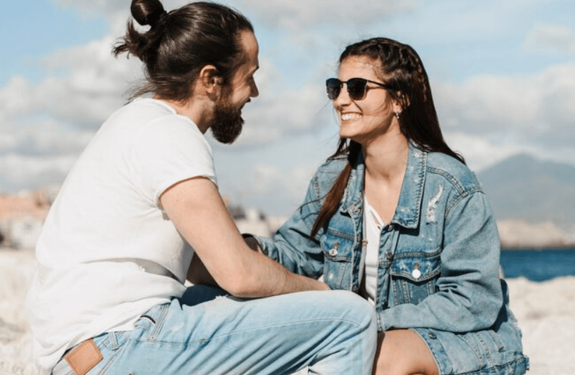 Two adults talking outdoors near the coast